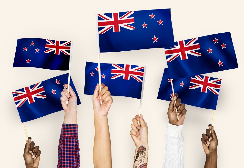 Hands waving flags of New Zealand